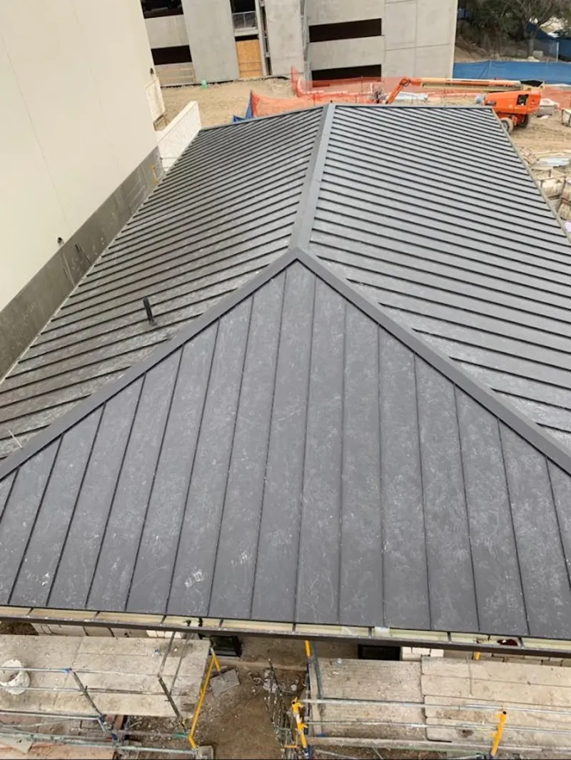 Commercial metal roof construction with crane equipment in Bellingham